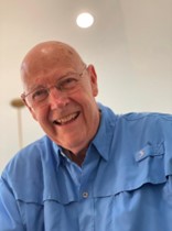 Tom, un paciente de cáncer, sonriendo, con una camisa azul