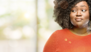 mujer negra con jersey naranja que parece escéptica. Los ensayos clínicos son un salvavidas para los pacientes marginados.
