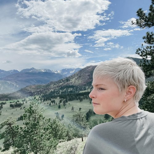 photo of Meagan McKee, profile in foreground against green valley and mountain horizon. Meagan is the author of this blog post, Is there a right way to die? 